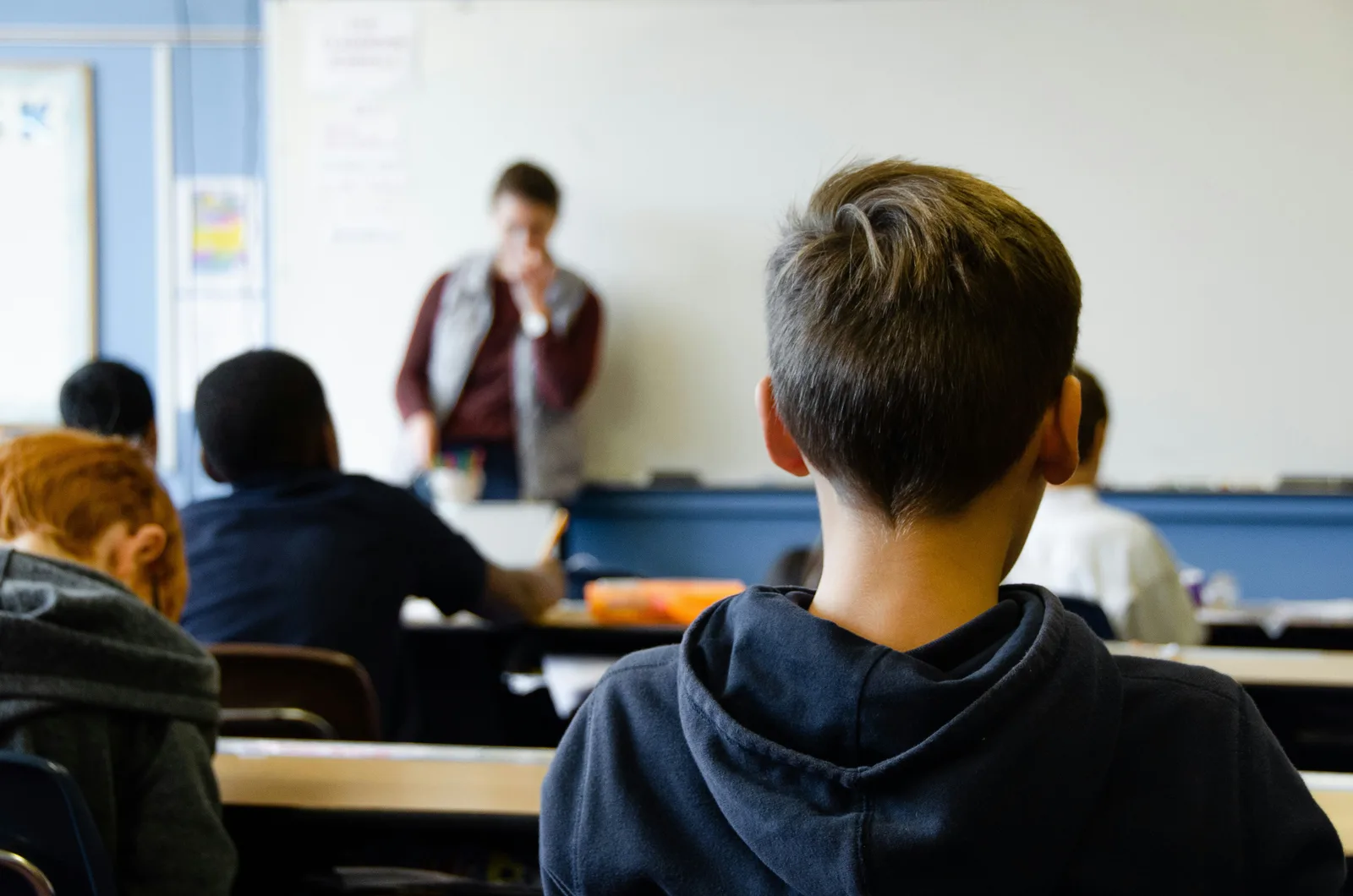 Students at their desks facing a teacher at the whiteboard